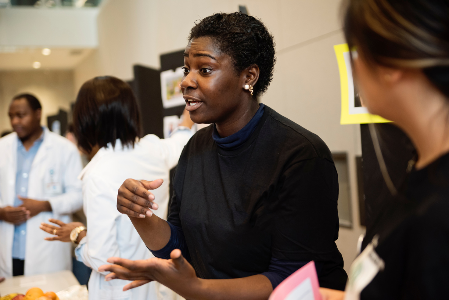 Young adult college student at their kiosk in science fair.